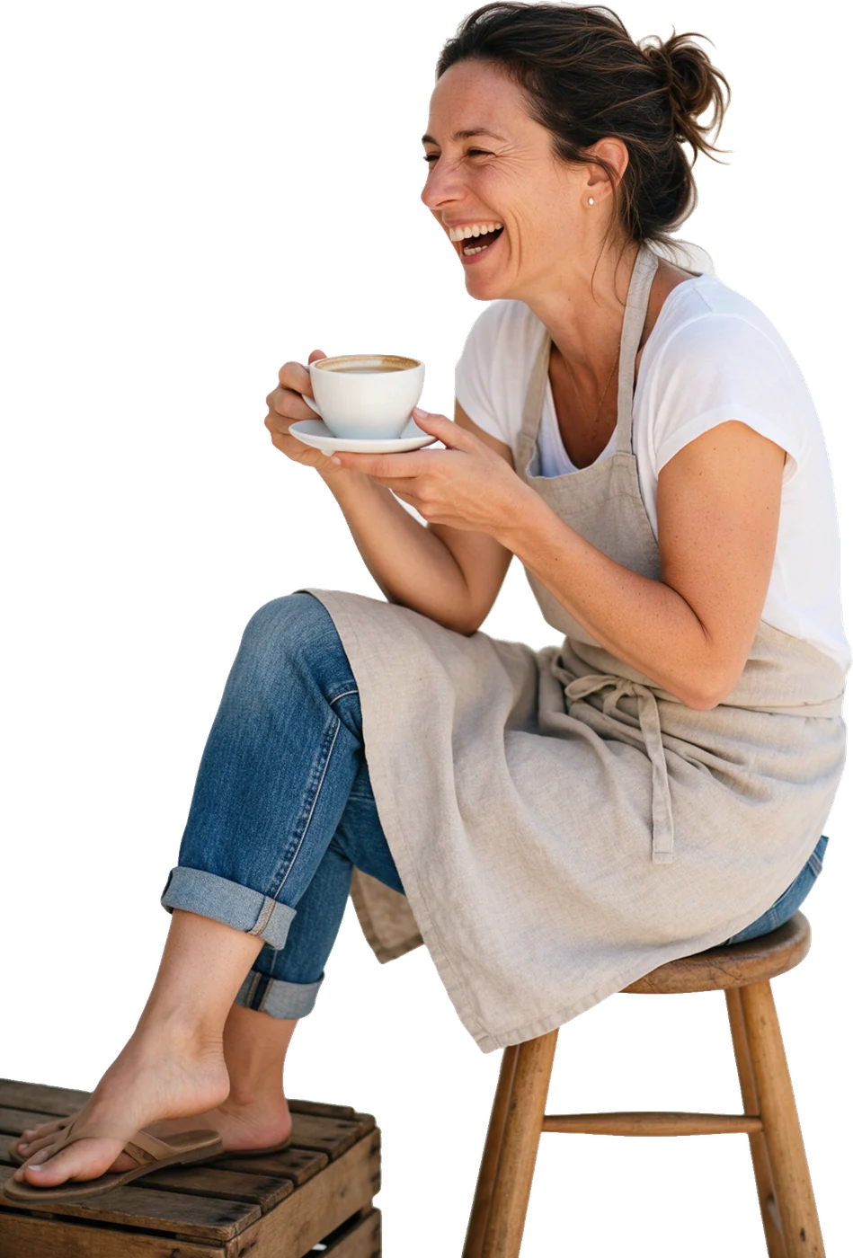 A bakery owner relaxing on a stool with a coffee